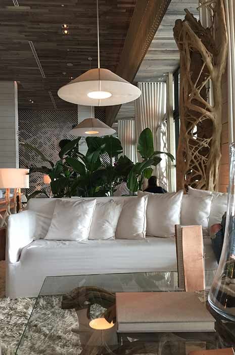 Luxuriöse Hotellobby im Bali Style mit gemütlichem Sofa, weichem Teppich und vielen Pflanzen - Hospitality-Trend