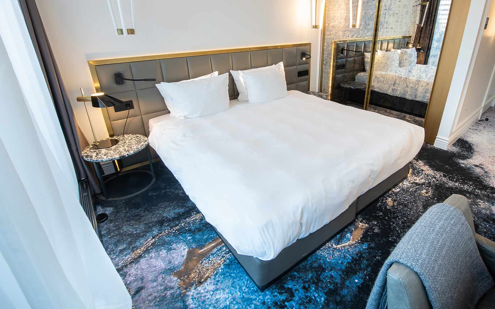 Hotel Teppichboden - Designthema 2: Hotelzimmer mit Teppich in den Farben des Baltikums dazu Goldakzente und schlichtes graues Mobiliar