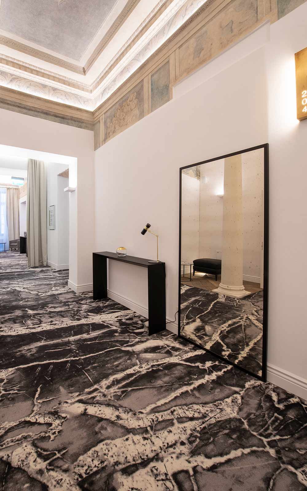 Hotel Teppichboden - Designthema 1: Hotelflur mit Teppichboden im Stil von schwarzem und weißen Marmor mit hellen Wänden und dunklem Mobiliar