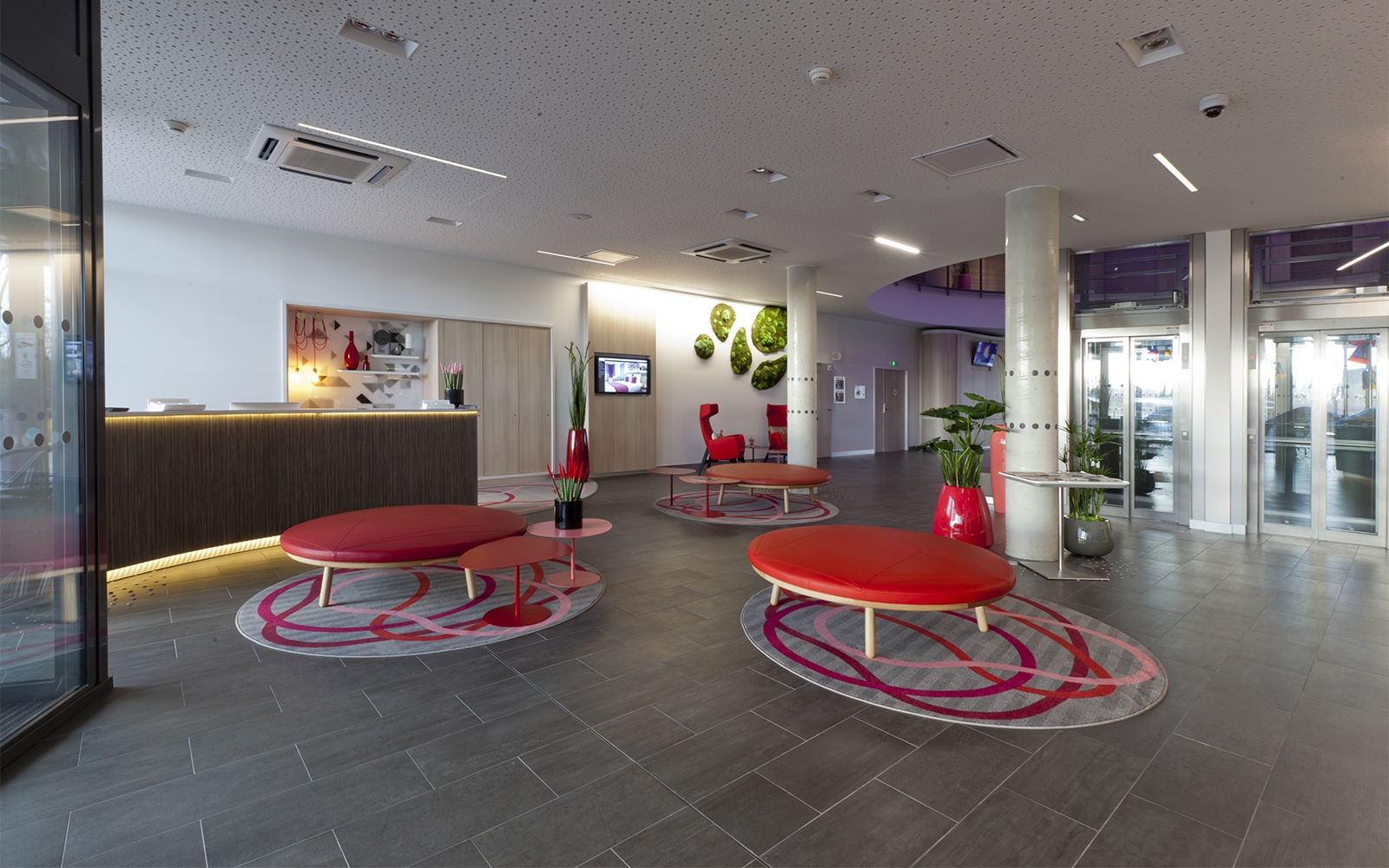 Hotelteppich: Abgepasste runde Teppiche mit geschwungenen Linien erzeugen kleine visuell-abgetrennte Sitzgruppen in der Hotellobby