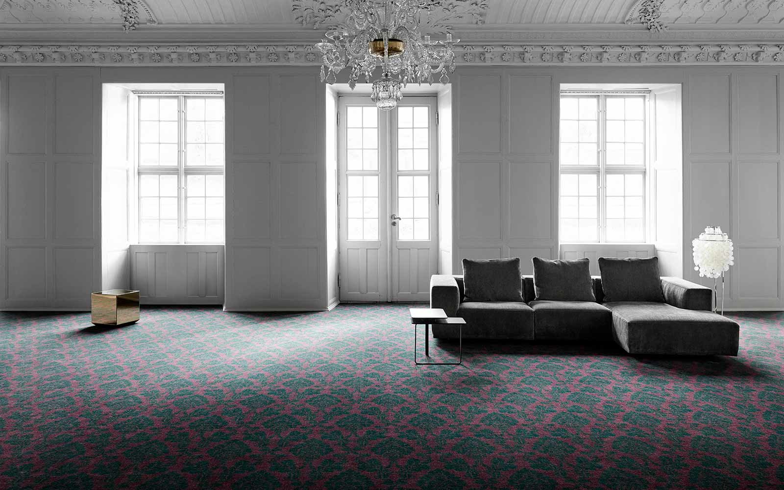Großer heller Raum mit Sofa und Kronleuchter und Teppichboden mit Textur